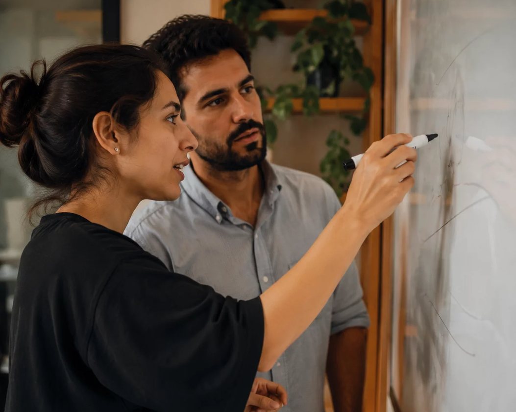 Pessoa em pé diante da turma sustentando um argumento com as anotações na mão